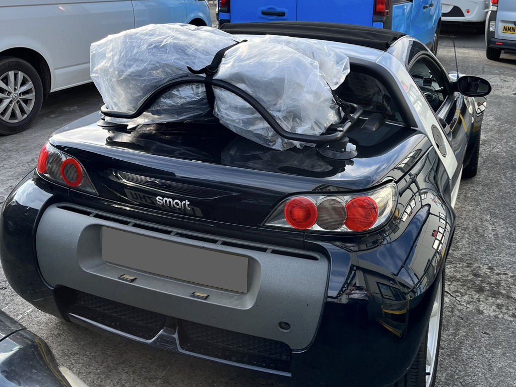 black smart roadster with a revo-rack luggage rack fitted carrying a bag