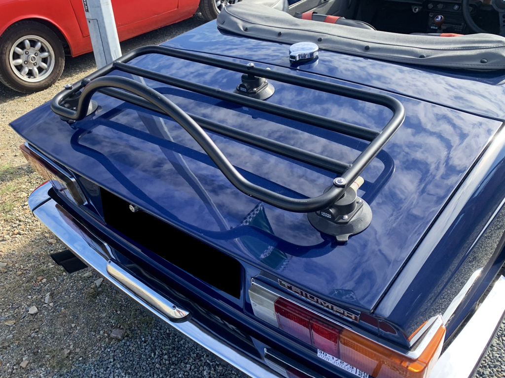 blue triumph tr6 with a black luggage rack fitted photographed close form the rear