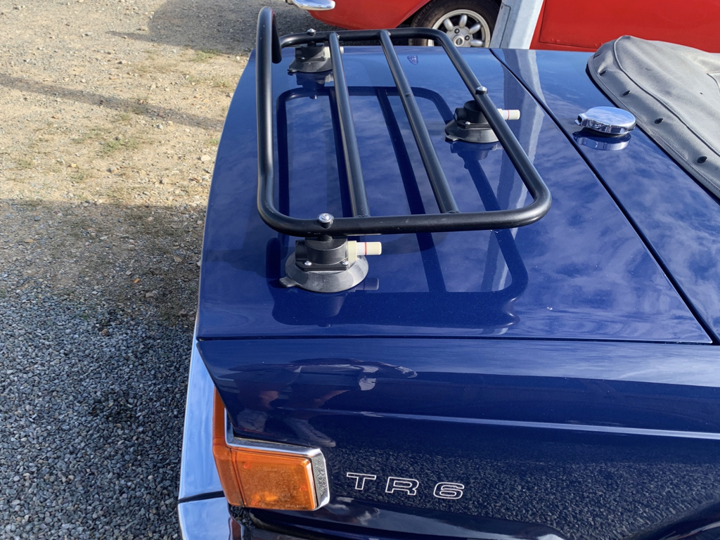 blue triumph tr6 with a black luggage rack fitted photographed close form the rear