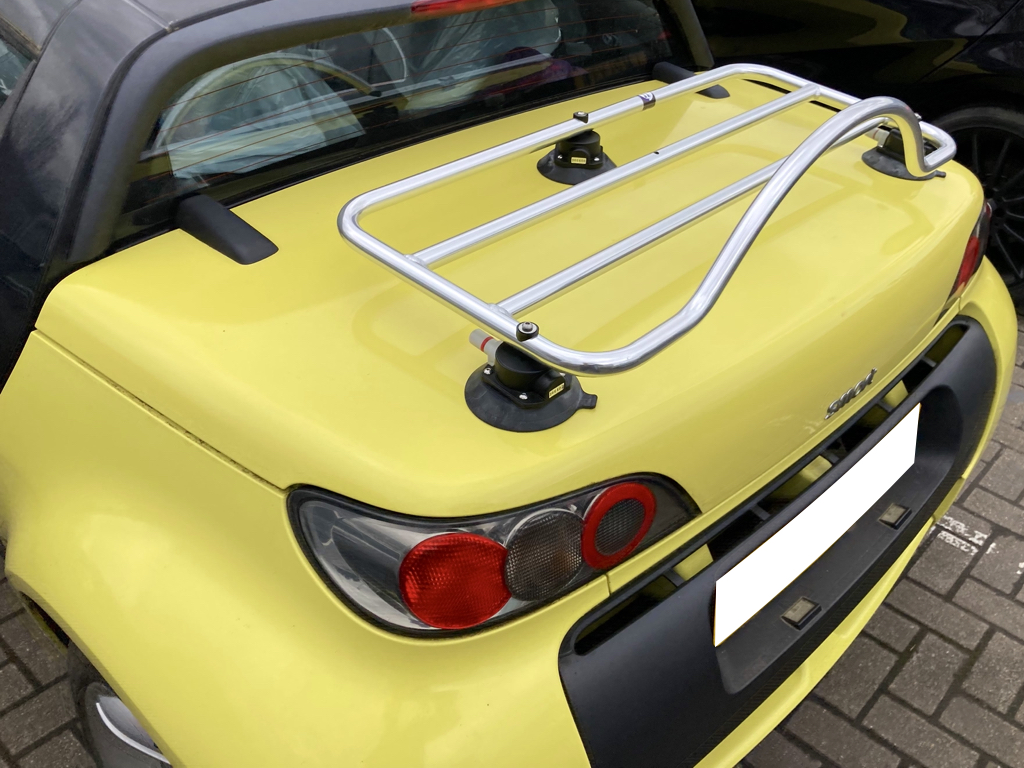 yellow smart roadster with a chrome boot rack fitted photographed close at the side