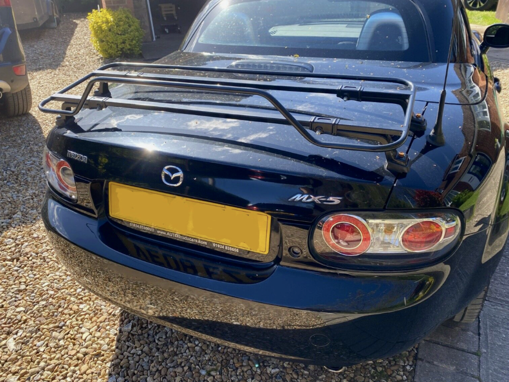 blue mazda mx5 mk3 with a black luggage rack fitted photographed close form the rear