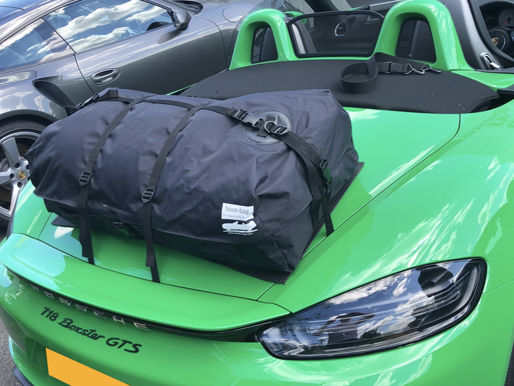 green porsche boxster 718 gts with a boot-bag vacation luggage rack fitted photographed close form the rear