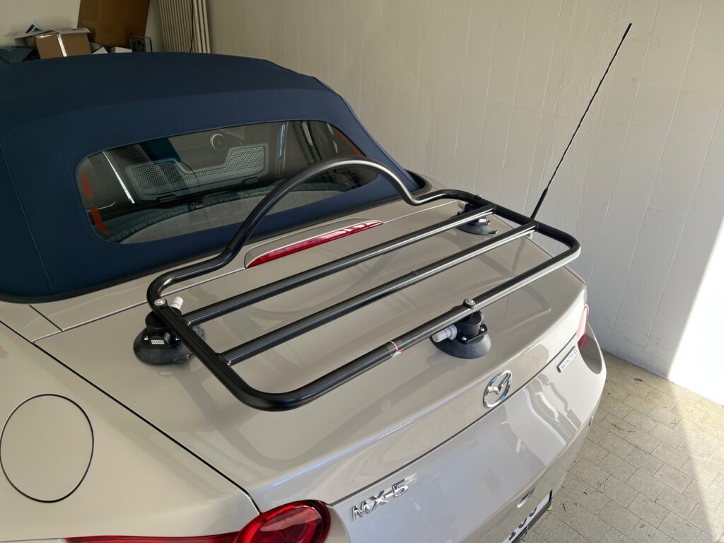 Biege cream mazda mx5 nd in a garage photographed from the rear with a revo-rack black luggage rack fitted to the trunk lid